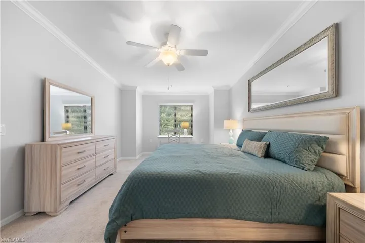 Bedroom with crown molding, ceiling fan, and light carpet