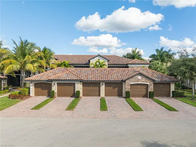 Mediterranean / spanish-style house featuring stucco siding, a tiled roof, community garages, and stone siding