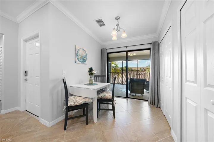 Dining space featuring crown molding, a chandelier, and light tile patterned flooring