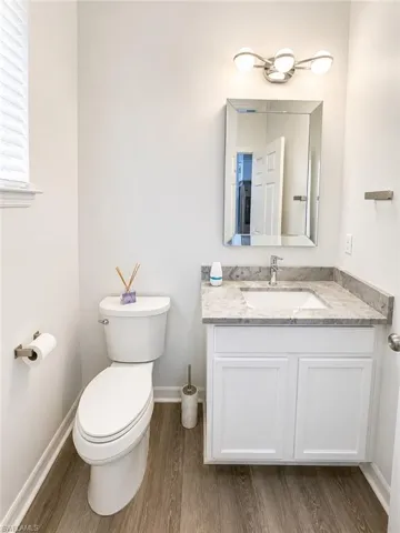 White vanity with a light-toned countertop and an undermount sink