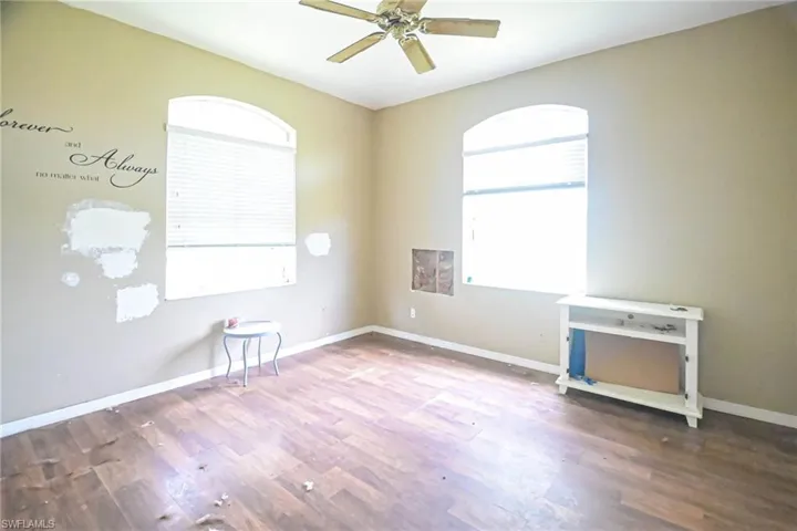 Unfurnished room with ceiling fan and hardwood / wood-style flooring