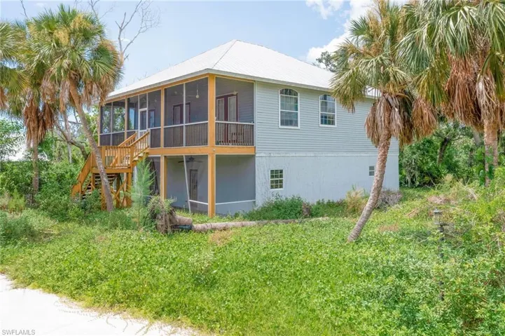 Back of house featuring a sunroom and a yard