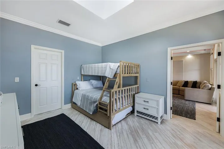 Bedroom with crown molding and light hardwood / wood-style floors