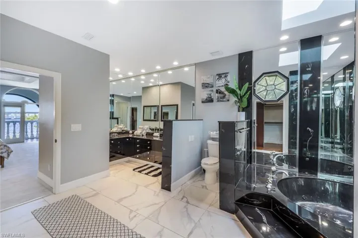 Bathroom with tile flooring, a bath, vanity, and toilet