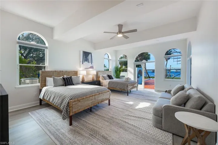 Bedroom featuring ceiling fan, multiple windows, and hardwood / wood-style flooring