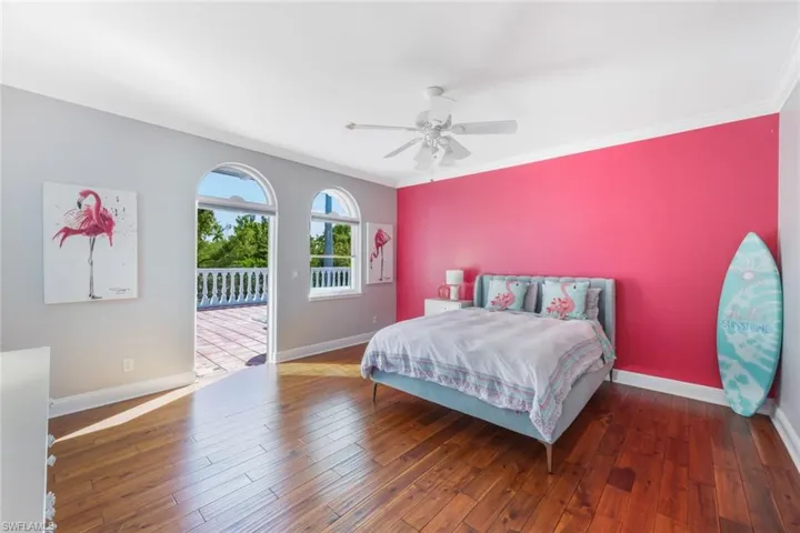 Bedroom featuring ceiling fan, dark hardwood / wood-style flooring, crown molding, and access to outside