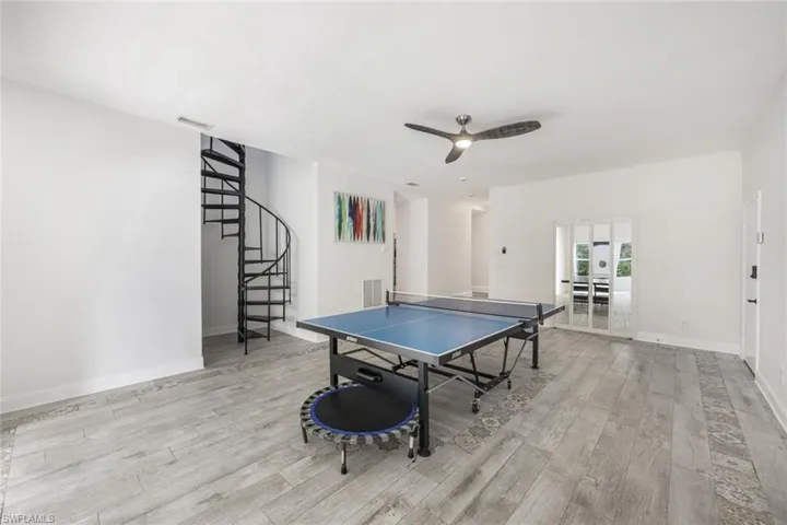 Recreation room featuring light wood-type flooring and ceiling fan