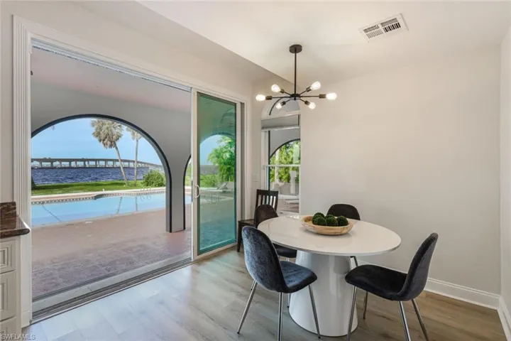 Dining area with an inviting chandelier, a wealth of natural light, and light wood-type flooring