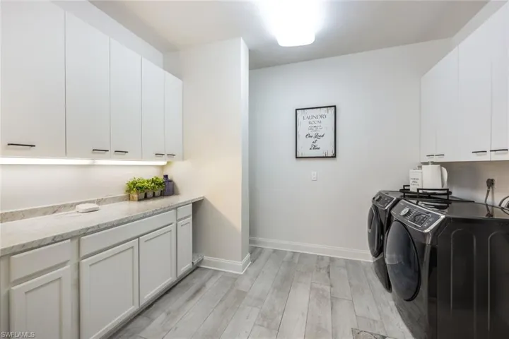 Laundry room with washer and clothes dryer, cabinets, light hardwood / wood-style floors, and hookup for an electric dryer