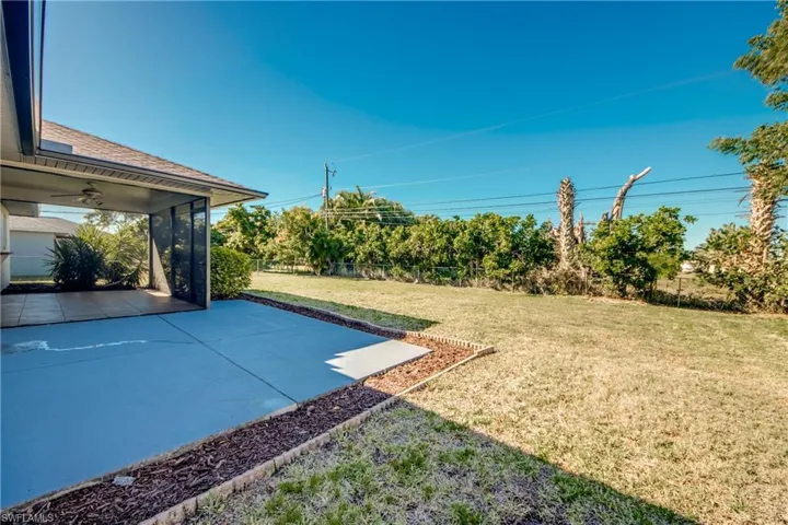 View of yard featuring a sunroom and ceiling fan