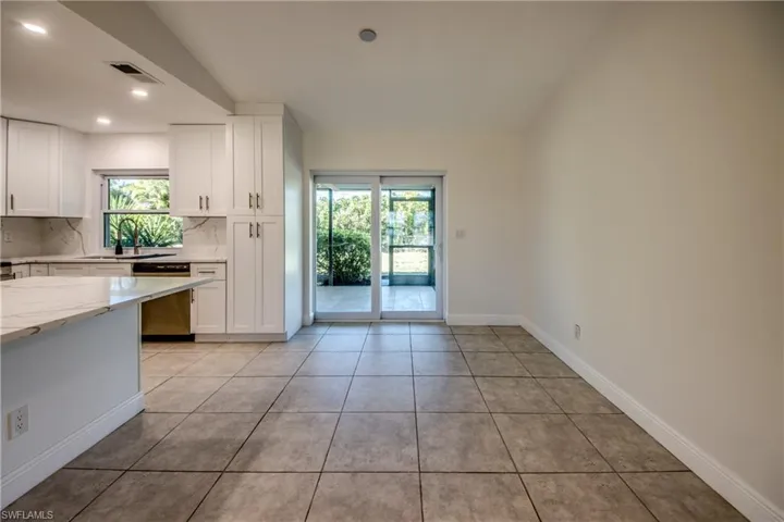 Kitchen featuring white cabinets, backsplash, light stone counters, dishwasher, and recessed lighting