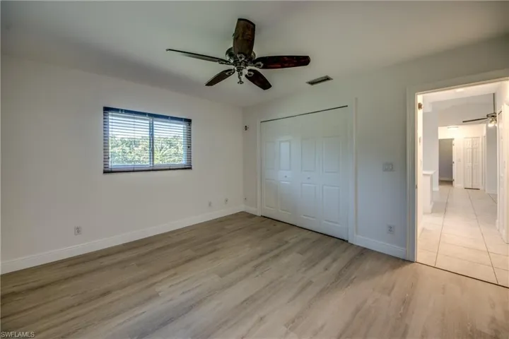 Unfurnished bedroom featuring light wood-type flooring, a ceiling fan, and a closet