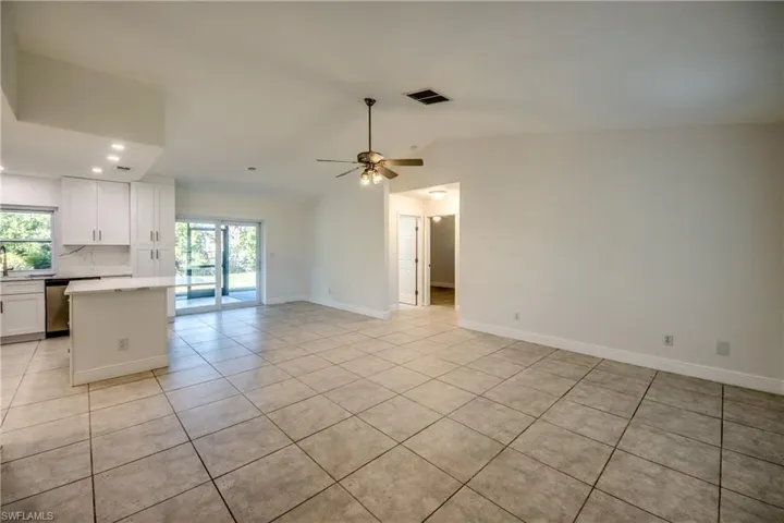 Unfurnished living room with light tile patterned floors, lofted ceiling, a ceiling fan, and recessed lighting