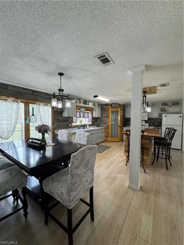 Dining area featuring a textured ceiling, light wood-style flooring, and a chandelier