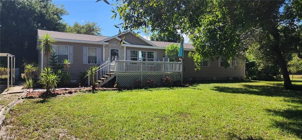 Ranch-style home featuring crawl space, stairs, a front yard, and a deck