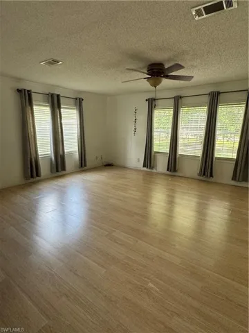Main Living Room featuring ceiling fan, light wood-style flooring, and a textured ceiling