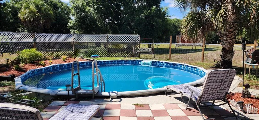 View of pool with fence and a patio