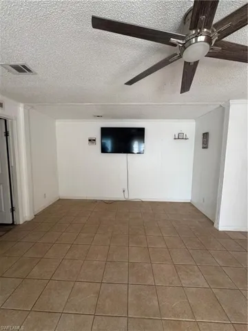 Livingroom outside of Master Bedroom featuring a textured ceiling, ceiling fan, and light tile patterned floors