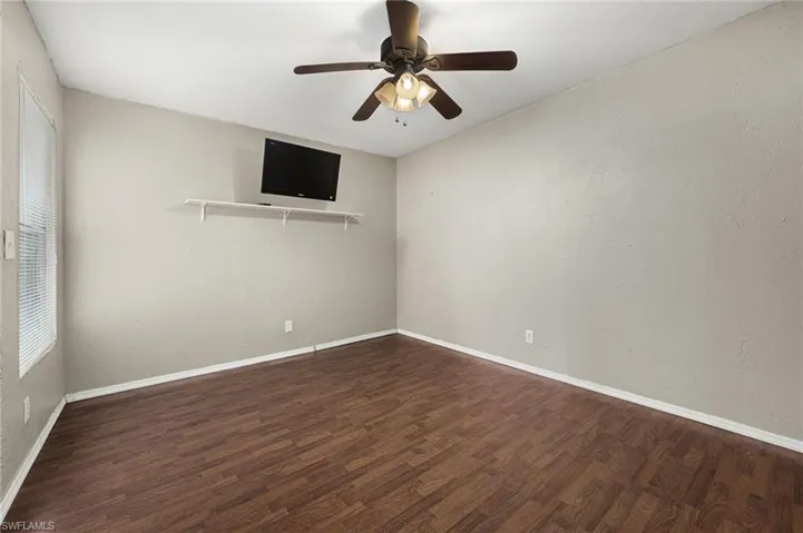 Spare room featuring ceiling fan and dark hardwood / wood-style flooring