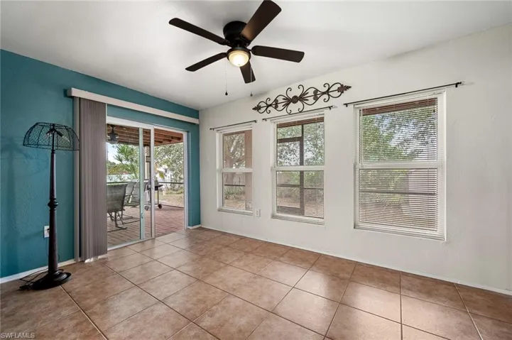 Tiled spare room featuring ceiling fan