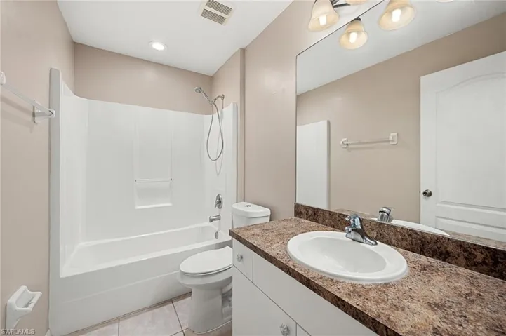 Full bathroom featuring shower / tub combination, toilet, tile patterned floors, and vanity