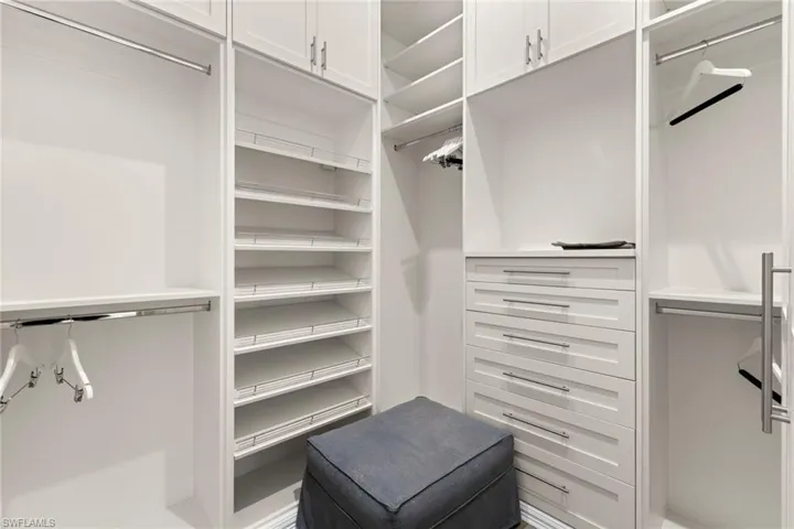 Bedroom featuring light wood-type flooring, a ceiling fan, a high ceiling, a tray ceiling, and recessed lighting