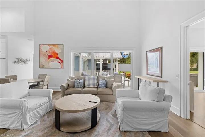 Living area featuring a chandelier, dark wood finished floors, a premium fireplace, and a high ceiling