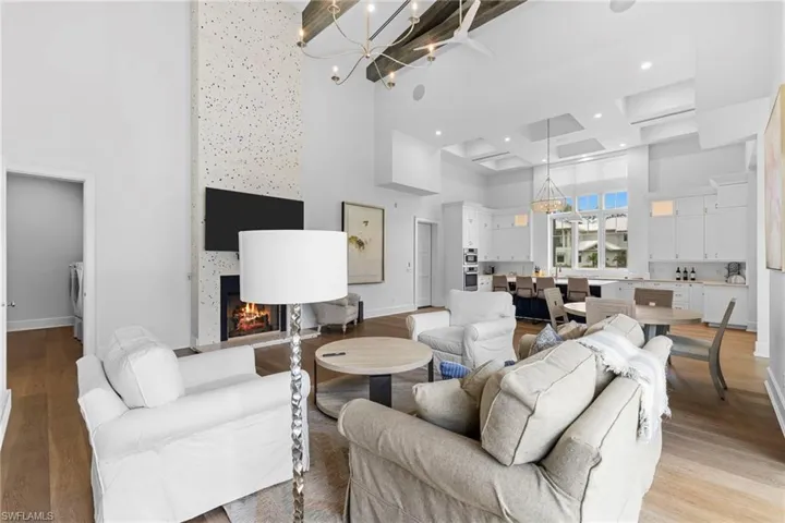 Kitchen with white cabinetry, a kitchen island with sink, a breakfast bar area, and a towering ceiling