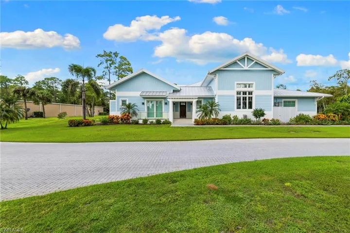 View of front of property featuring a front lawn, a standing seam roof, and a metal roof