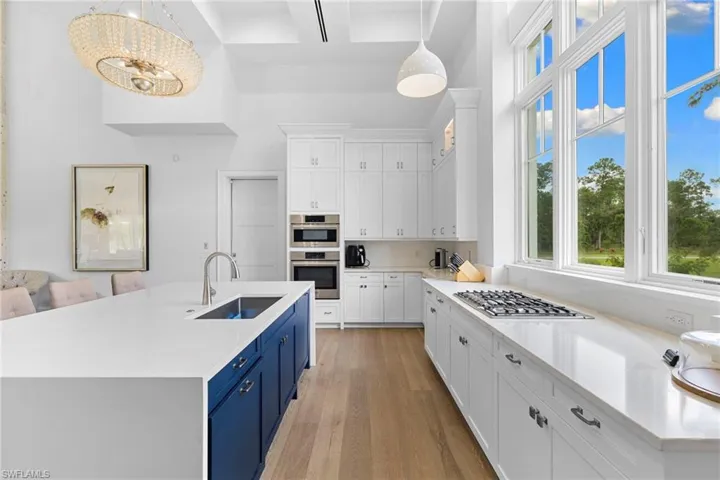 Kitchen view of white cabinets, light stone counters, and stainless steel gas cooktop