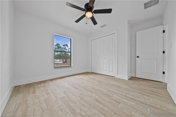 Unfurnished bedroom with light wood-style flooring, a ceiling fan, and a closet