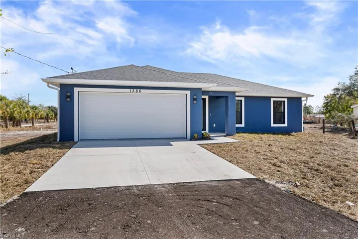 Ranch-style home featuring driveway, stucco siding, a shingled roof, and an attached garage