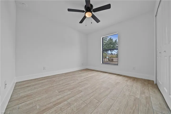Empty room with light wood-style flooring and ceiling fan