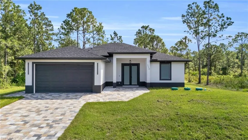 View of front of property featuring a front yard and a garage