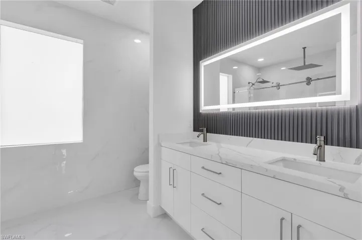 Bathroom with walk in shower, vanity, and toilet
