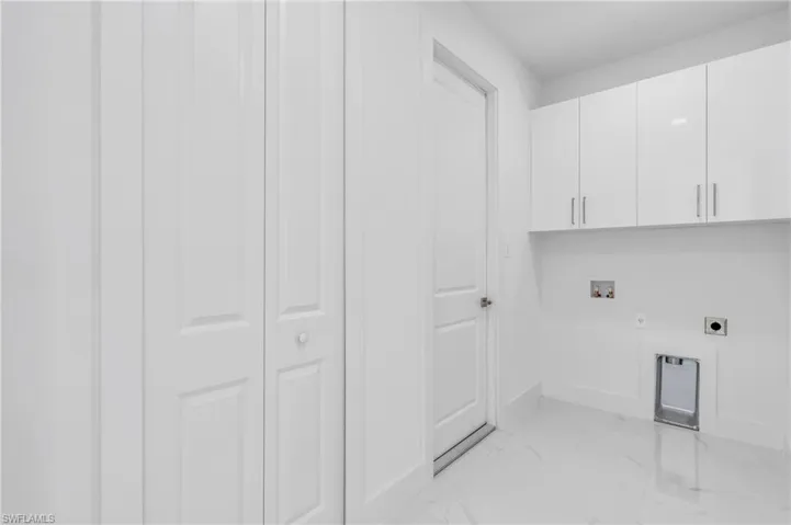 Laundry room with hookup for a washing machine, electric dryer hookup, and cabinets