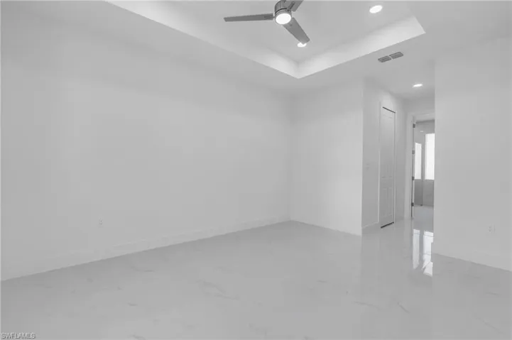 Empty room with a tray ceiling and ceiling fan