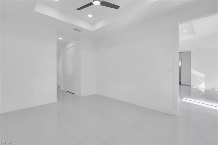 Spare room with ceiling fan and a raised ceiling