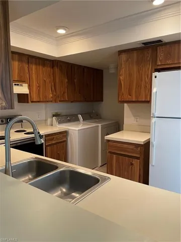 Sink,  fridge, premium range hood, independent washer and dryer, and ornamental molding