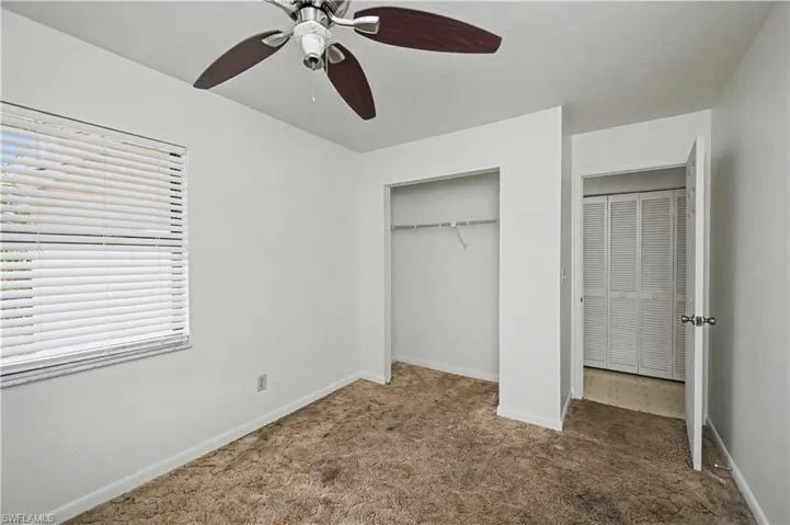 Unfurnished bedroom with carpet floors, a closet, and a ceiling fan