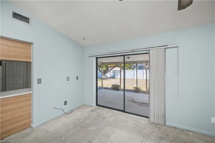 Spare room featuring vaulted ceiling and baseboards