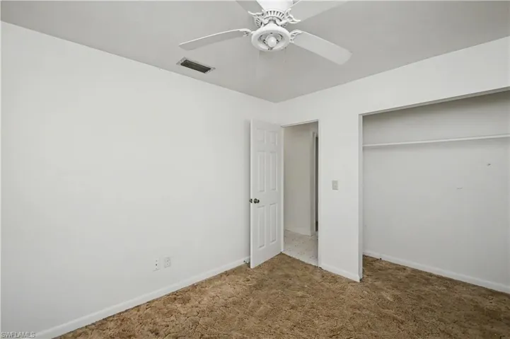 Unfurnished bedroom featuring carpet floors, a closet, and ceiling fan