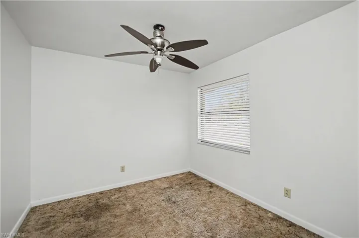 Unfurnished room featuring carpet floors and ceiling fan