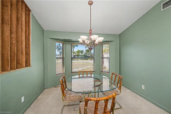 Carpeted dining room featuring a chandelier and lofted ceiling