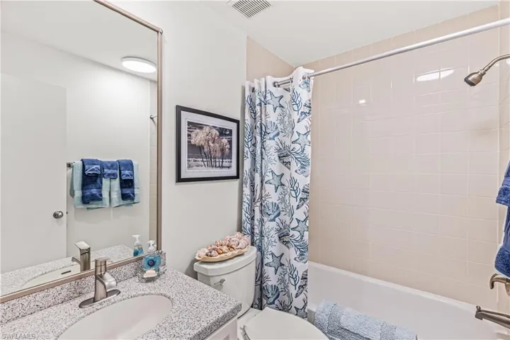 Full bath featuring shower / bath combo with shower curtain and vanity