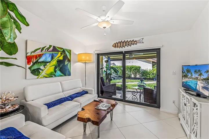 Tiled living room featuring a ceiling fan