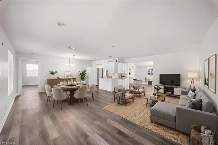 Open-concept interior featuring wood-finish flooring, recessed lighting, and white cabinetry