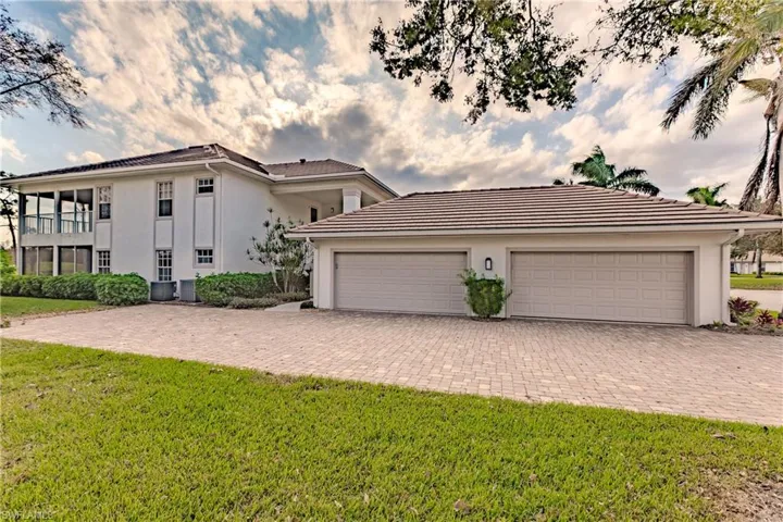 View of front of home featuring a front lawn, a garage, and a balcony