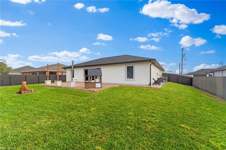Back of property with a patio area and a lawn