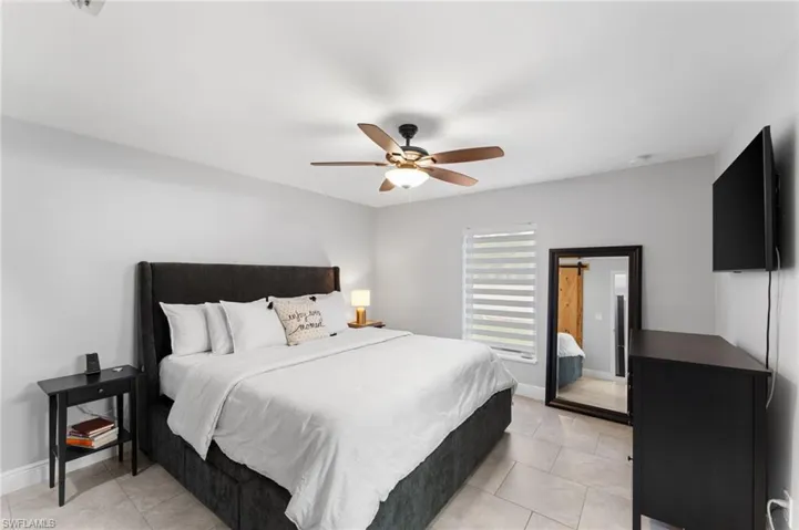 Bedroom with light tile patterned floors and ceiling fan